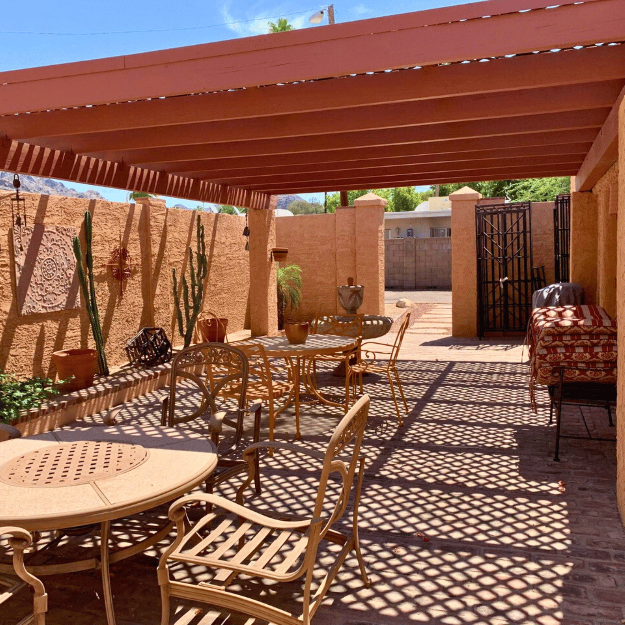 a patio with tables and chairs under a red awning